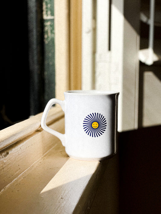 Allways coffee mug with logo on windowsill in afternoon light