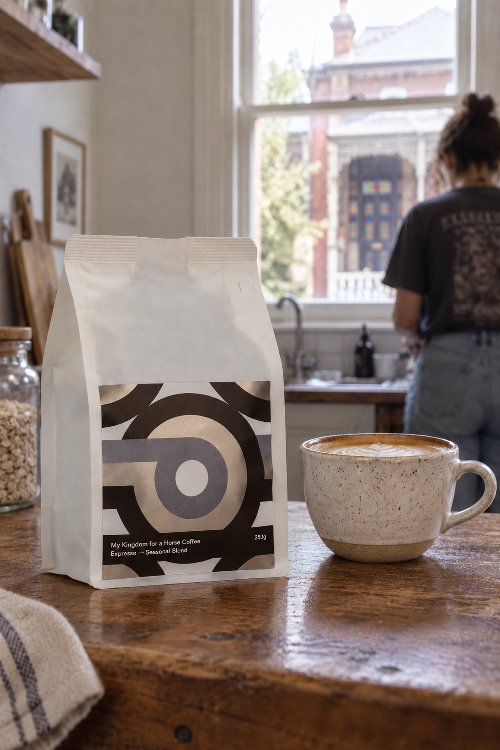 My Kingdom for a Horse Seasonal Blend coffee bag with a flat white on a timber kitchen bench.