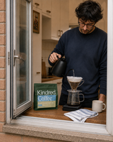 Kindred Mwito coffee bag beside a V60 pour-over brewed through an open kitchen window